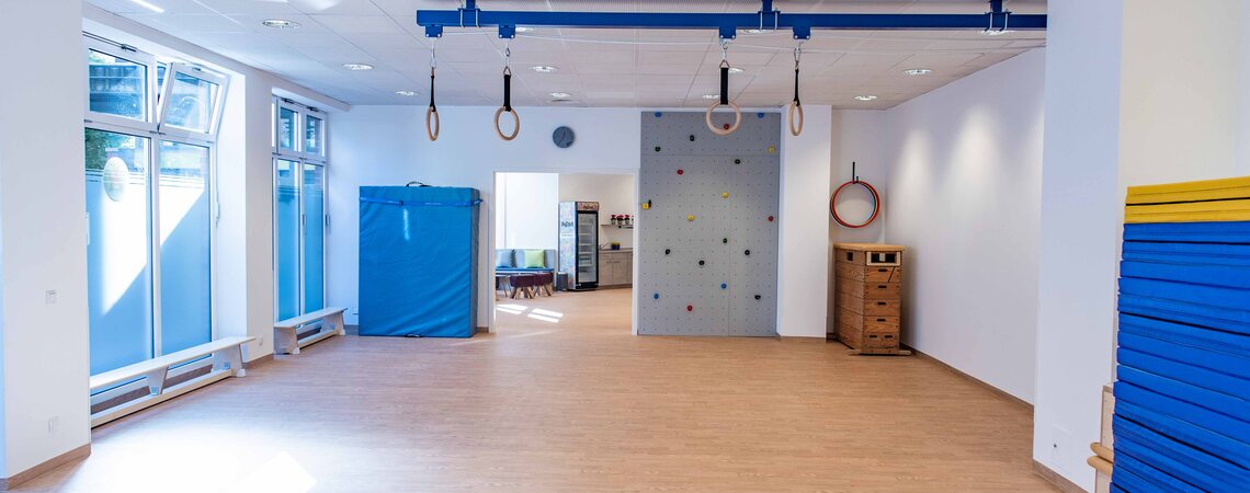 Der helle SportRaum mit Kletterwand und Ringen